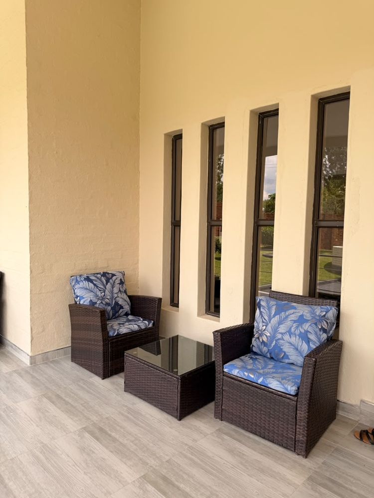 Wicker armchairs with blue cushions on the veranda